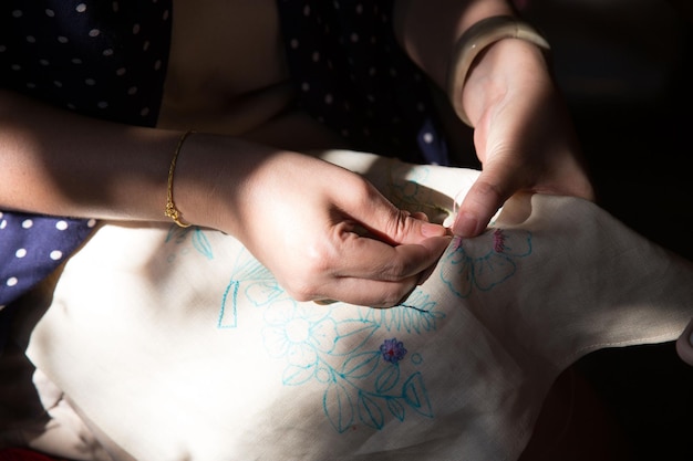 ręce haftujące tkaninę